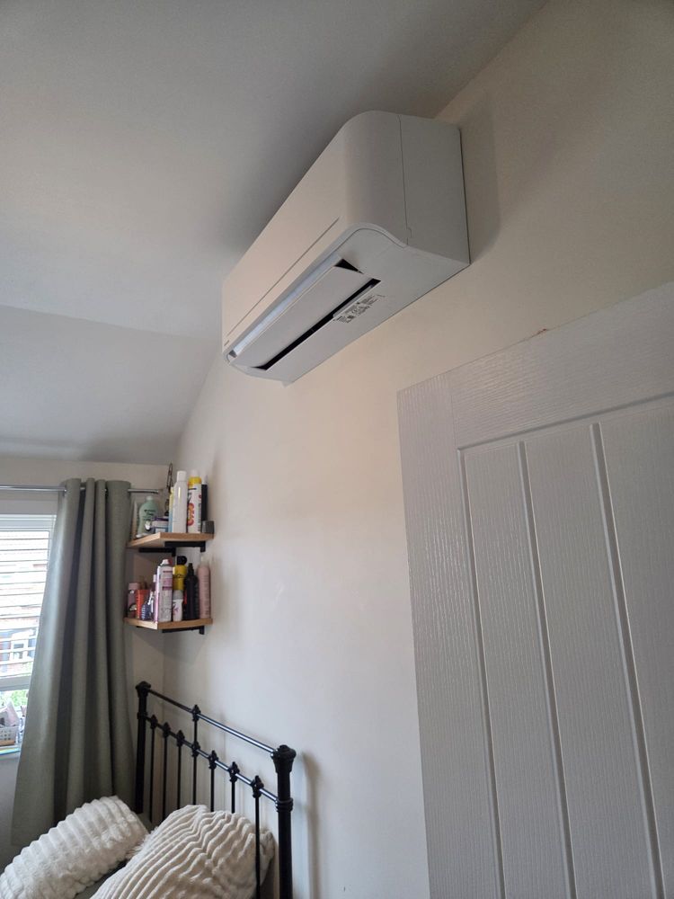 Wall-mounted indoor unit above a bedroom door