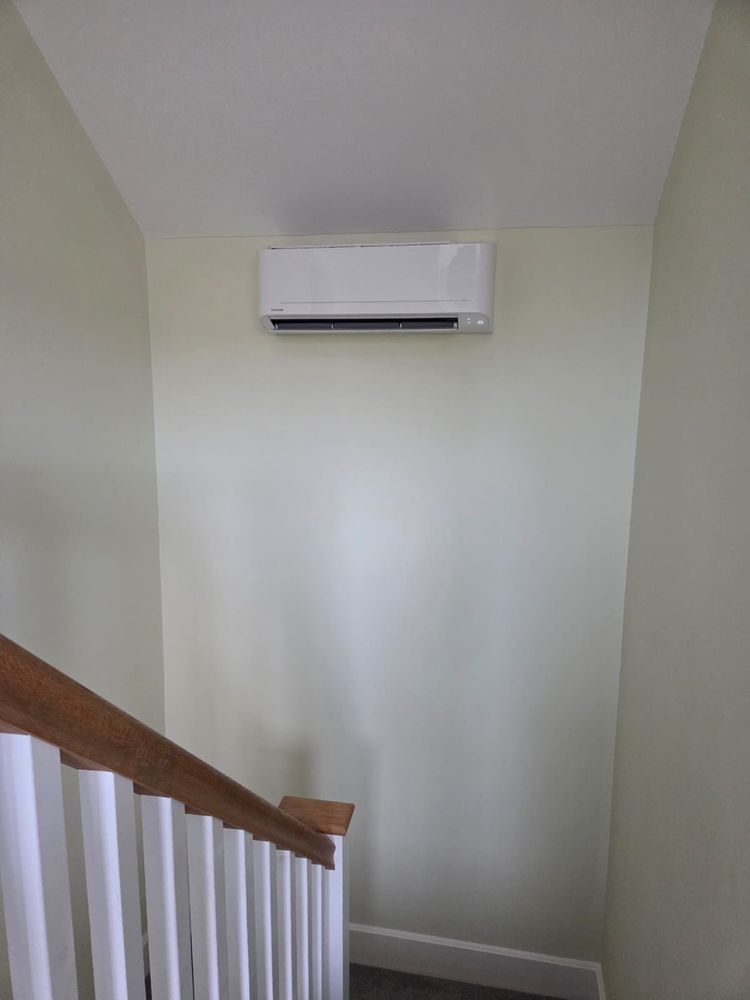 Indoor unit on a landing wall above the stairs