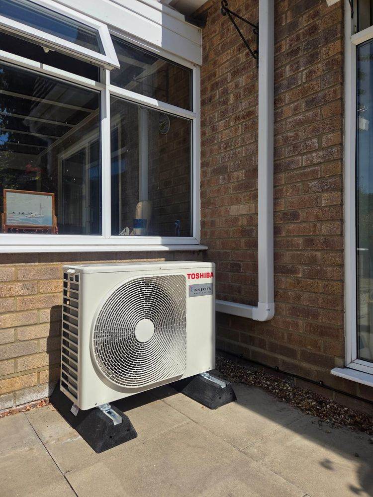 Toshiba outdoor unit on anti-vibration feet beside a patio